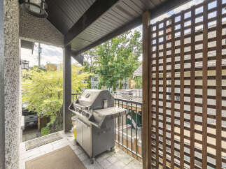 Enjoy outdoor living on this spacious balcony, perfect for entertaining with a built-in grill and ample seating space.
