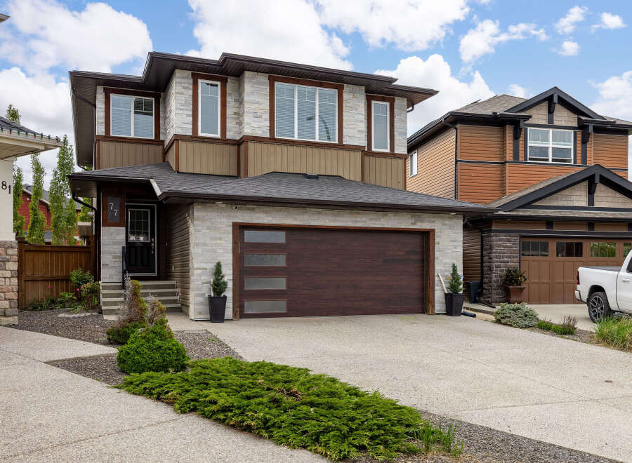 Discover modern living in this stunning two-story home featuring a striking stone and wood exterior.