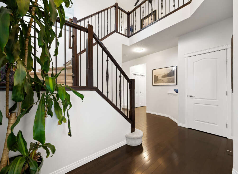 Step into this grand foyer featuring a sweeping staircase with rich dark wood railings and elegant spindles.