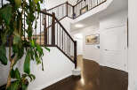 Step into this grand foyer featuring a sweeping staircase with rich dark wood railings and elegant spindles.