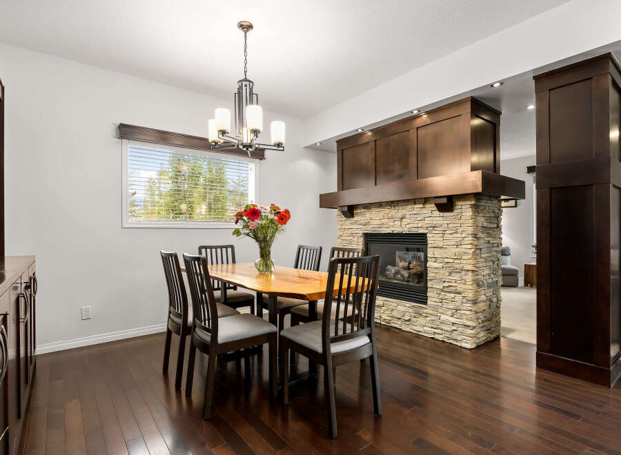 Experience elegant dining in this beautifully appointed space, featuring a live-edge wood dining table surrounded by six chairs.
