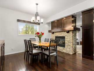 Experience elegant dining in this beautifully appointed space, featuring a live-edge wood dining table surrounded by six chairs.
