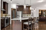 Experience luxury in this stunning kitchen featuring rich dark wood cabinetry and a spacious granite island perfect for entertaining.