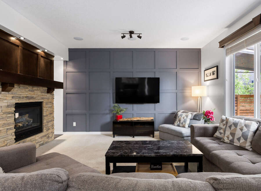 Experience ultimate comfort in this inviting living room, featuring a stunning stone fireplace and a modern media wall.