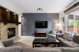 Experience ultimate comfort in this inviting living room, featuring a stunning stone fireplace and a modern media wall.