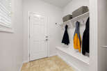 This entryway features a white door with a six-panel design, complemented by a built-in white bench with storage.