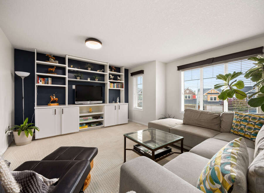 This inviting living room features a built-in entertainment center with ample shelving and cabinetry, perfect for displaying decor and storing media.