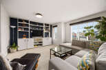 This inviting living room features a built-in entertainment center with ample shelving and cabinetry, perfect for displaying decor and storing media.