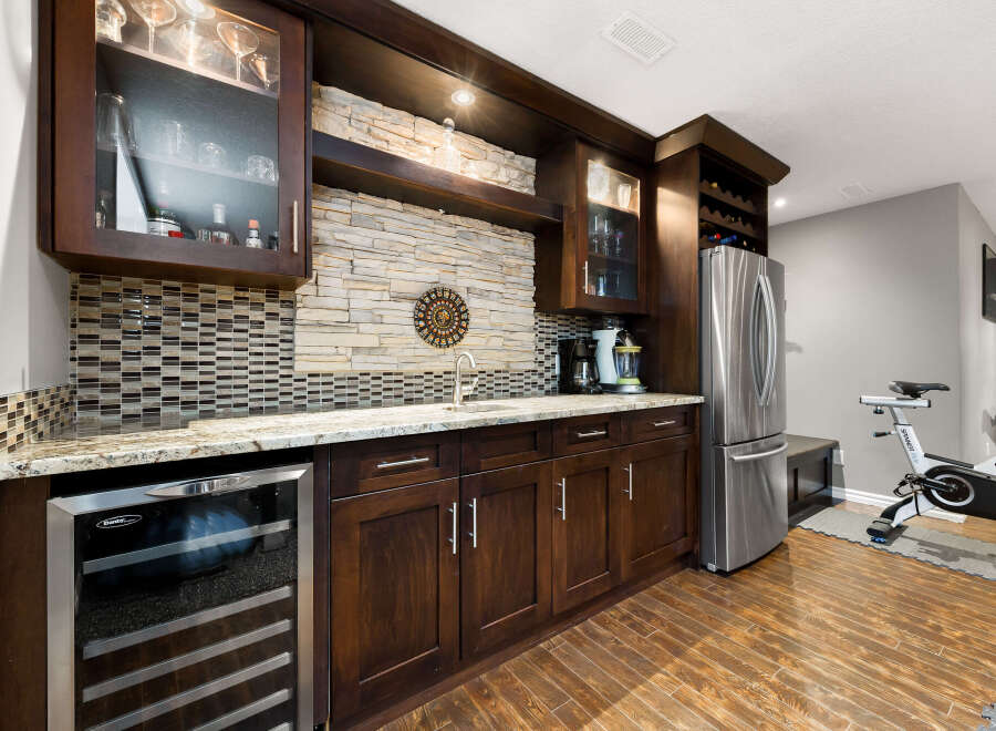 This home features a stylish wet bar area perfect for entertaining, complete with a wine fridge, sink, and ample cabinet space.