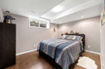 Discover this charming bedroom featuring a comfortable bed with a stylish striped comforter and coordinating pillows.