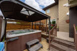 Experience ultimate relaxation in this backyard oasis, featuring a luxurious hot tub under a protective gazebo.