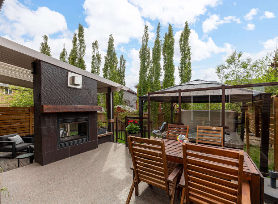 Experience ultimate relaxation in this luxurious backyard oasis, featuring a covered patio with a modern fireplace and a spacious dining area perfect for al fresco entertaining.