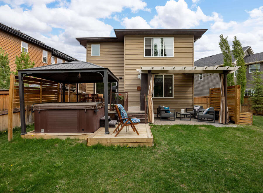 Enjoy ultimate relaxation in this backyard oasis, featuring a luxurious hot tub under a protective gazebo.