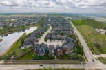 Discover this stunning suburban neighborhood featuring modern homes with diverse architectural styles, nestled alongside a serene pond and lush green spaces.