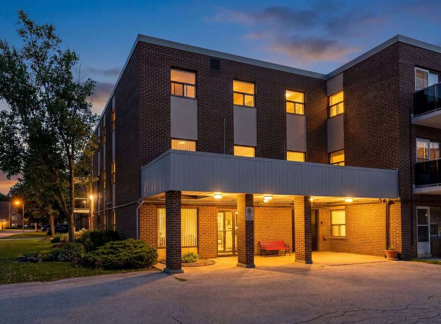 Experience comfortable living in this charming brick building, beautifully illuminated at dusk.