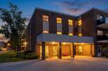 Experience comfortable living in this charming brick building, beautifully illuminated at dusk.