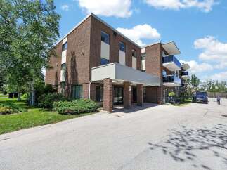 Discover modern living in this brick apartment building featuring sleek balconies with glass railings and ample natural light.