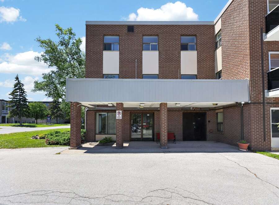 Discover comfortable living in this charming brick building, featuring a covered entrance for easy access and a welcoming facade.
