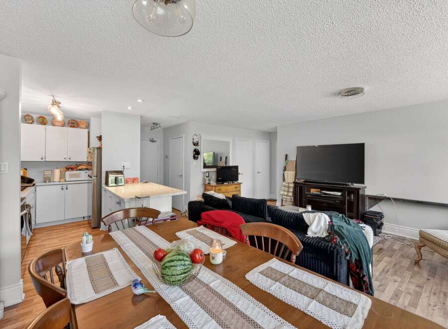 This open-concept living space features a well-equipped kitchen with ample cabinet space and a breakfast bar, perfect for casual dining.