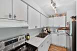 Discover this charming kitchen featuring sleek white cabinetry and a durable marble-patterned countertop.