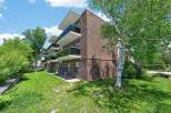 Discover modern living in this charming brick apartment building, featuring sleek balconies with glass railings perfect for enjoying the outdoors.
