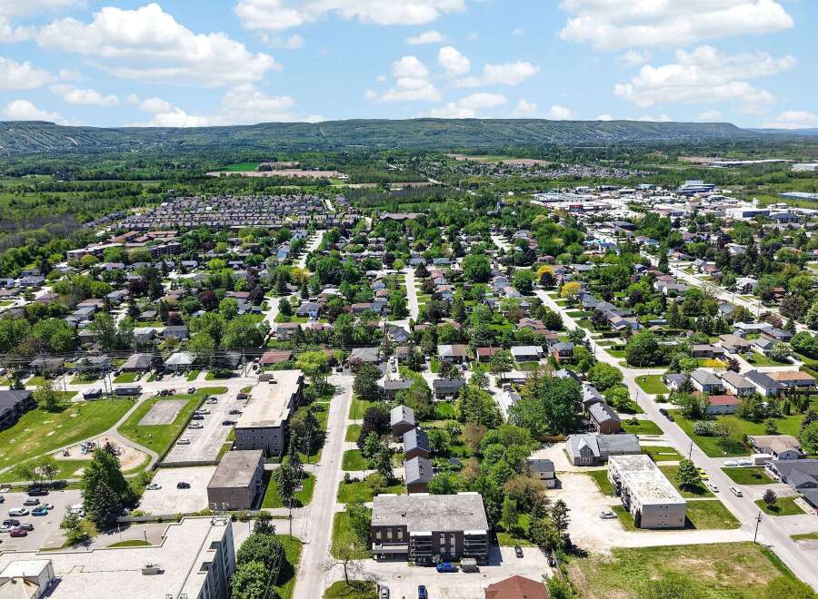 Discover this charming residential neighborhood with a mix of single-family homes and apartment buildings, nestled amidst lush greenery and mature trees.