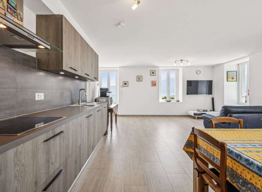 Experience modern living in this beautifully appointed apartment, featuring a sleek, integrated kitchen with ample cabinet space and a stylish backsplash.