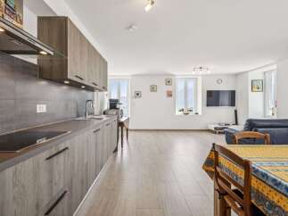 Experience modern living in this beautifully appointed apartment, featuring a sleek, integrated kitchen with ample cabinet space and a stylish backsplash.