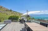 Experience breathtaking lake and mountain views from this stunning outdoor living space, perfect for entertaining or relaxing.