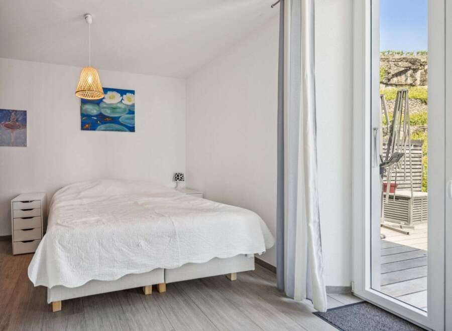 This charming bedroom features a comfortable queen-sized bed with a white quilted comforter, perfect for a restful night's sleep.