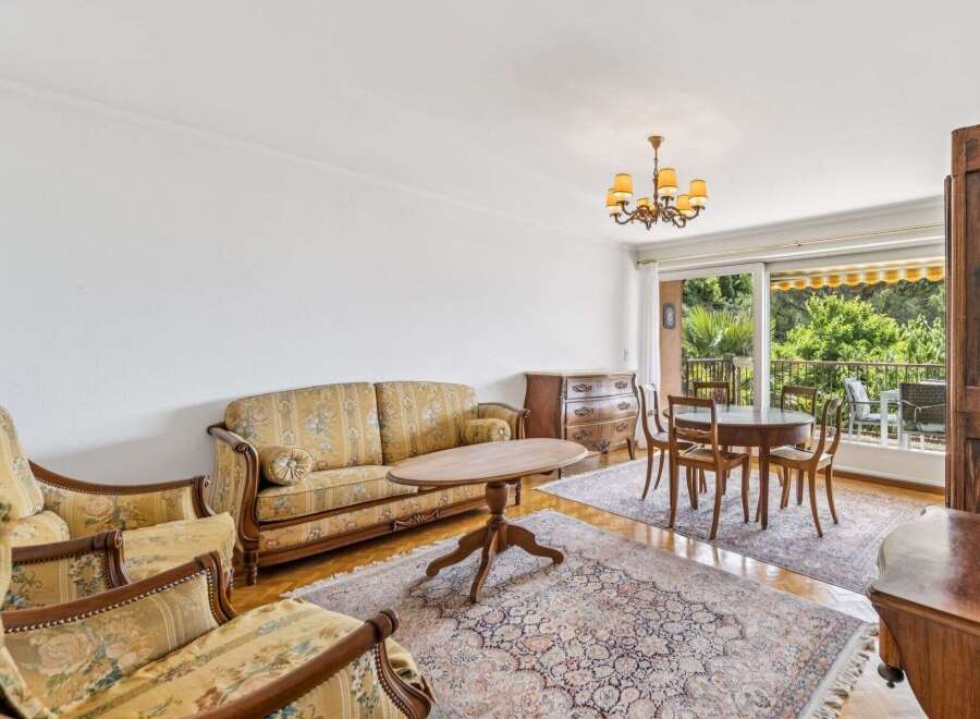 Step into this charming living and dining area, featuring a floral-patterned sofa and armchairs that exude classic elegance.