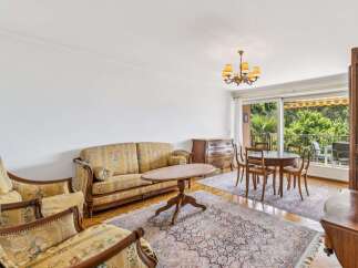 Step into this charming living and dining area, featuring a floral-patterned sofa and armchairs that exude classic elegance.