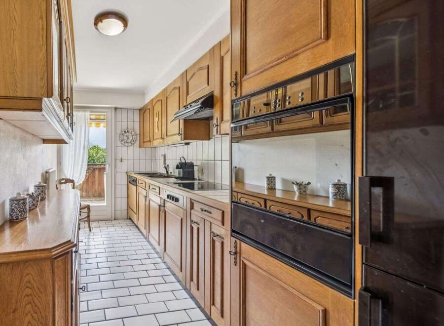 Discover this charming kitchen featuring warm wooden cabinetry and a classic tiled backsplash.