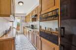 Discover this charming kitchen featuring warm wooden cabinetry and a classic tiled backsplash.