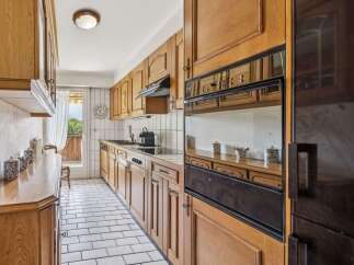 Discover this charming kitchen featuring warm wooden cabinetry and a classic tiled backsplash.