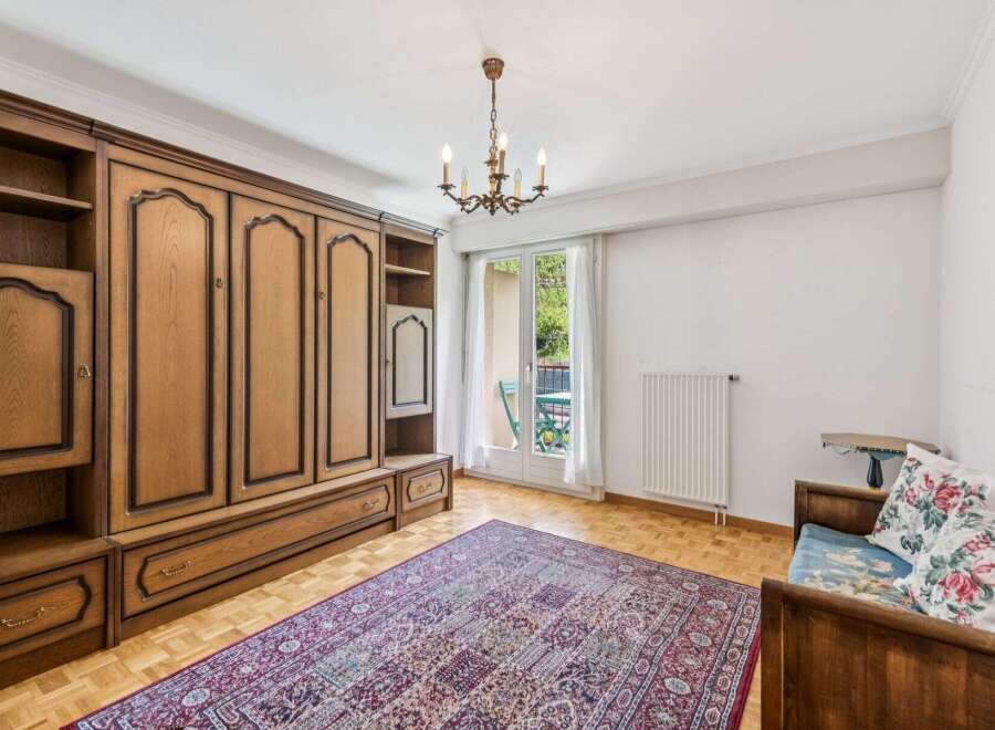 This charming room features a large, built-in wooden wardrobe offering ample storage space.