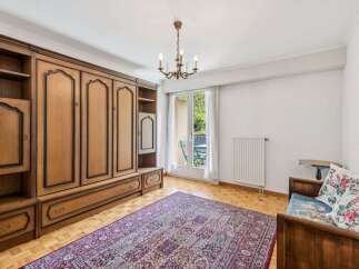 This charming room features a large, built-in wooden wardrobe offering ample storage space.
