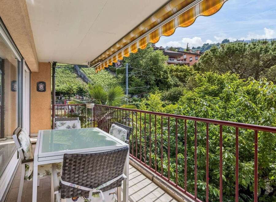 Enjoy your morning coffee on this charming balcony overlooking lush greenery and rolling hills.