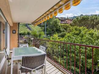 Enjoy your morning coffee on this charming balcony overlooking lush greenery and rolling hills.