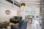 Experience modern living in this spacious open-concept home featuring a vaulted ceiling and a striking stone fireplace.