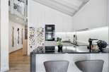 Experience modern living in this stunning kitchen featuring sleek white cabinetry and a sophisticated black granite countertop.