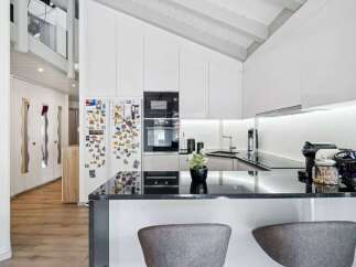 Experience modern living in this stunning kitchen featuring sleek white cabinetry and a sophisticated black granite countertop.