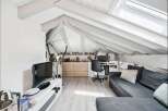 Discover this charming attic space, perfect for a home office and relaxation area.