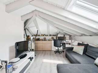 Discover this charming attic space, perfect for a home office and relaxation area.