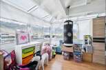 This sunroom offers a versatile space for play and relaxation, featuring a punching bag and a toy kitchen.