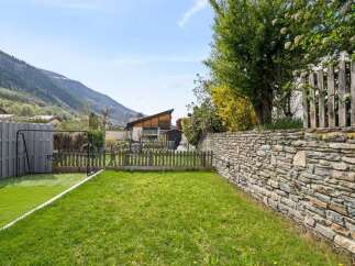 Enjoy outdoor living in this charming backyard featuring a lush green lawn perfect for recreation and relaxation.