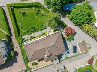 Discover this stunning aerial view of a modern home featuring a spacious, well-maintained lawn and a neatly trimmed hedge.