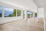 Experience breathtaking panoramic views from this spacious living area, featuring expansive windows that showcase stunning mountain and lake vistas.