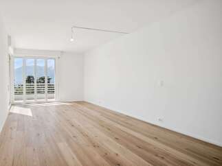 Experience modern living in this bright and airy room featuring a stunning panoramic view of the mountains through expansive glass doors.