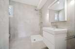 This modern bathroom features a spacious walk-in shower with a rainfall showerhead, perfect for a relaxing experience.